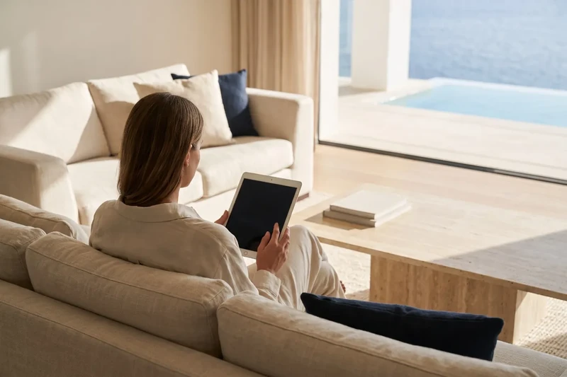 Woman reading on a tablet in a living room with sea views