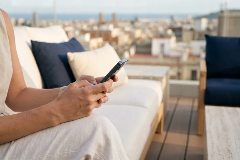Mans amb un mòbil a la terrassa d'un àtic de Barcelona